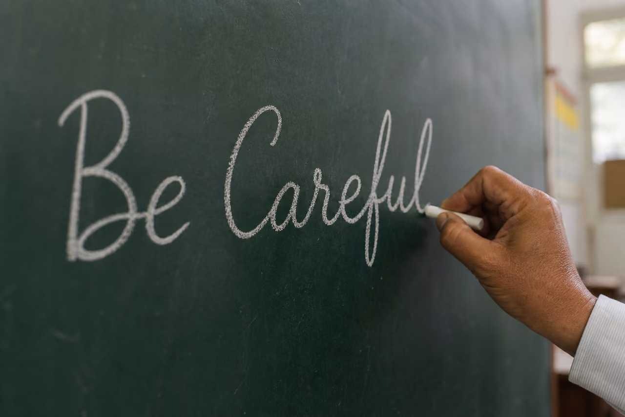 Teacher Writing Be Careful on a Green Chalkboard